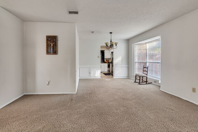 unfurnished living room with light carpet and a textured ceiling