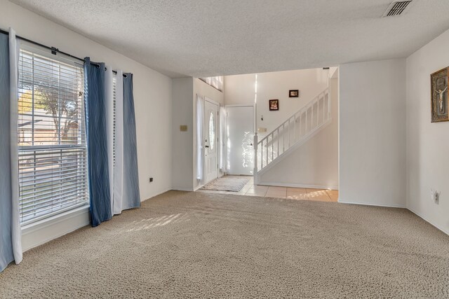 interior space with light carpet and a textured ceiling