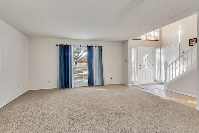 interior space with light carpet and a textured ceiling