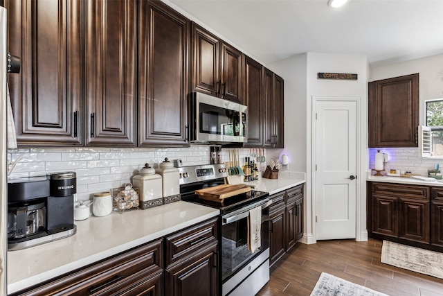 kitchen featuring dark hardwood / wood-style floors, dark brown cabinets, appliances with stainless steel finishes, and tasteful backsplash