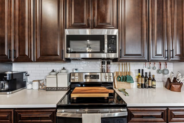 kitchen with tasteful backsplash, dark brown cabinets, and appliances with stainless steel finishes