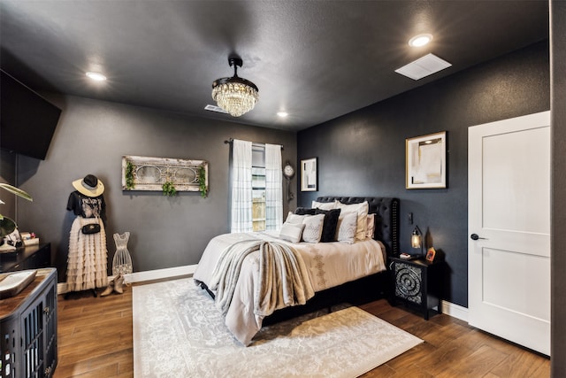 bedroom featuring dark wood-type flooring and a notable chandelier