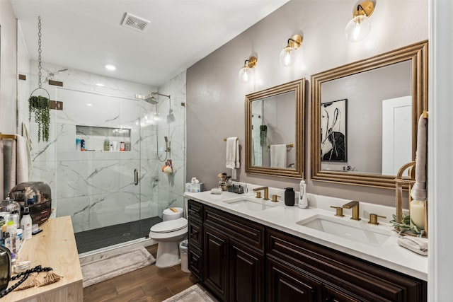 bathroom with hardwood / wood-style floors, vanity, toilet, and a shower with door