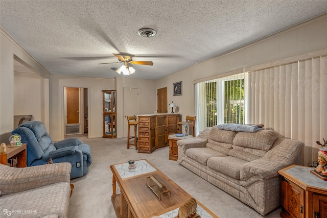 carpeted living room with ceiling fan and a textured ceiling