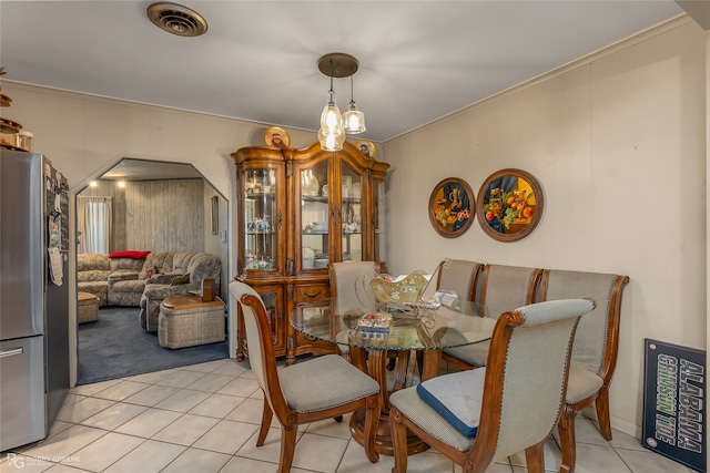 tiled dining room with crown molding and a notable chandelier