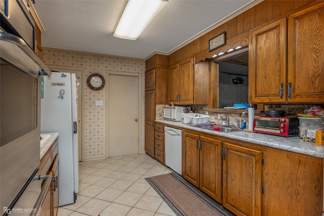 kitchen featuring light tile patterned flooring, white appliances, and sink