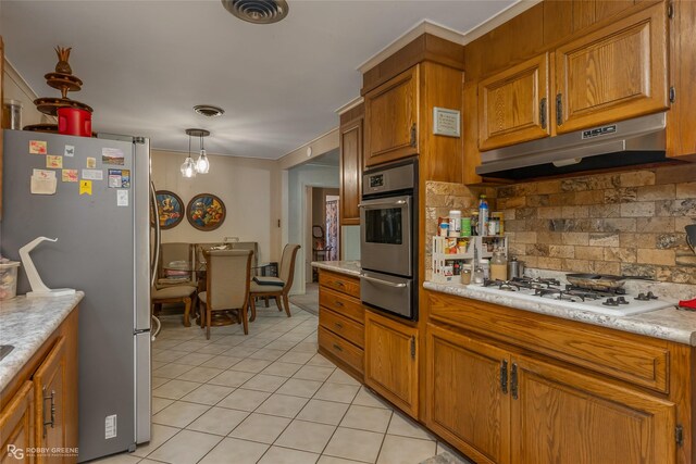 kitchen featuring tasteful backsplash, a notable chandelier, decorative light fixtures, light tile patterned floors, and appliances with stainless steel finishes