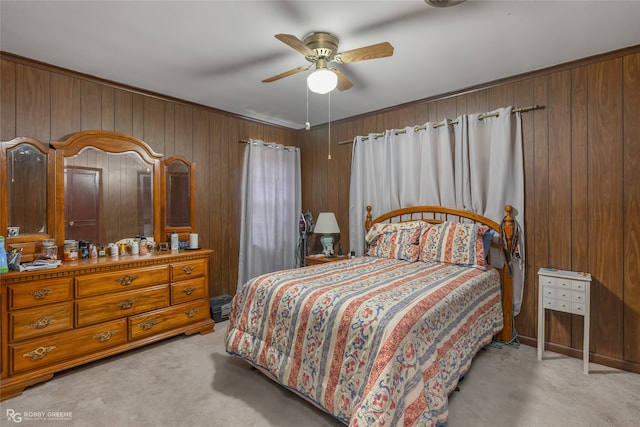 bedroom featuring light carpet, ceiling fan, and wooden walls