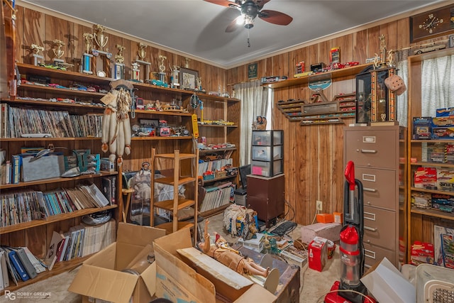 misc room featuring ceiling fan, wooden walls, and carpet