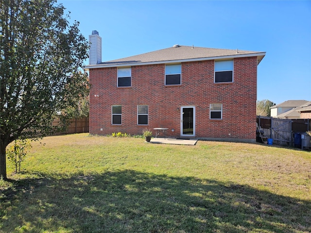 back of house featuring a lawn and a patio