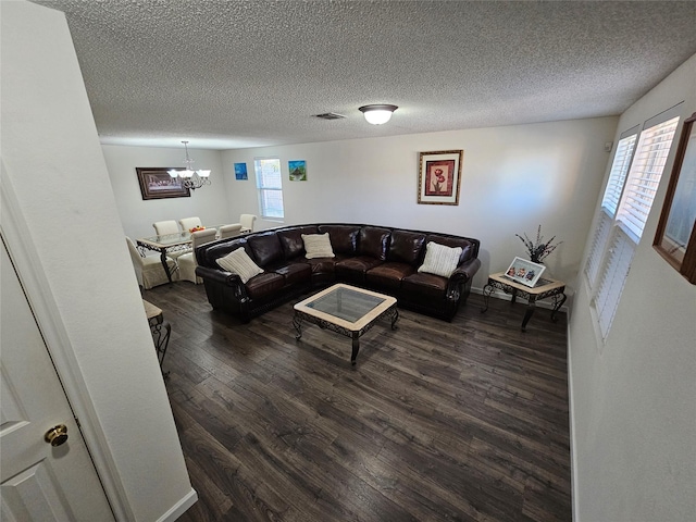 living room featuring a textured ceiling, dark hardwood / wood-style flooring, and a healthy amount of sunlight