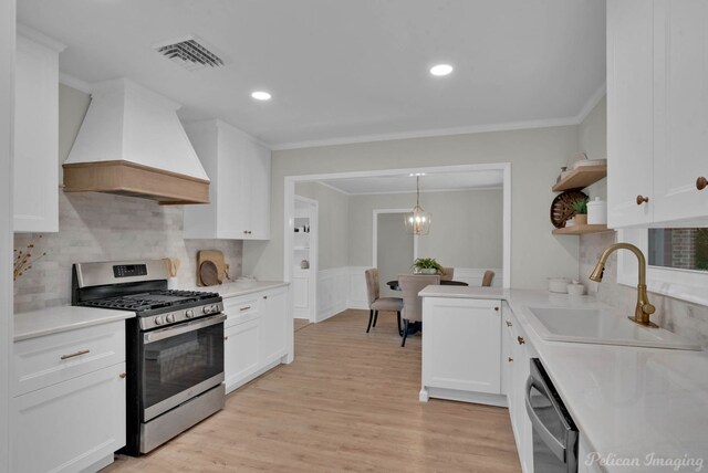 kitchen featuring appliances with stainless steel finishes, custom exhaust hood, sink, pendant lighting, and white cabinetry