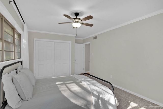 bedroom featuring carpet, ceiling fan, ornamental molding, and a closet