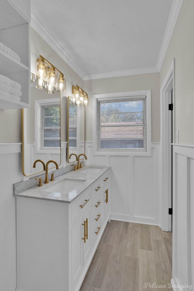 bathroom with hardwood / wood-style flooring, vanity, a healthy amount of sunlight, and ornamental molding