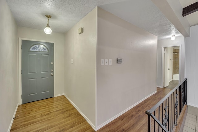 foyer entrance with hardwood / wood-style floors and a textured ceiling