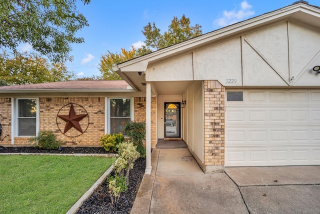 view of exterior entry featuring a garage and a lawn