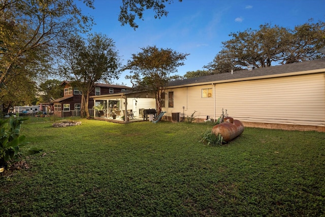 rear view of property featuring central AC and a yard