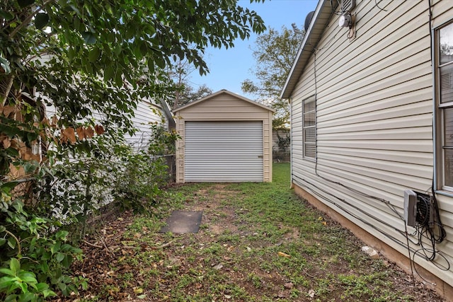 view of yard with a garage and an outbuilding