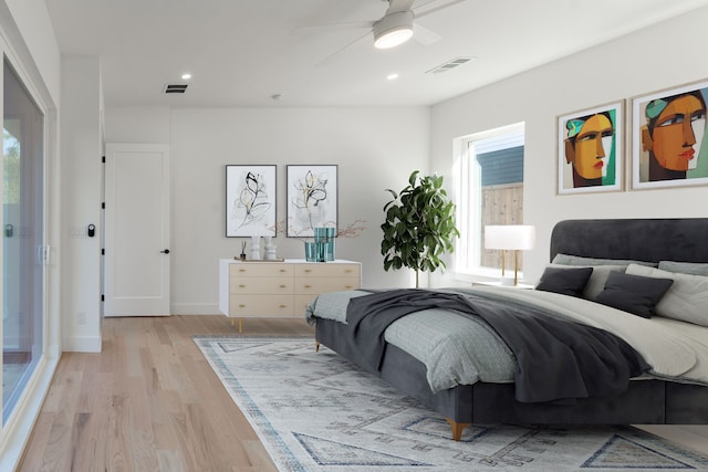 bedroom with multiple windows, ceiling fan, and light hardwood / wood-style floors