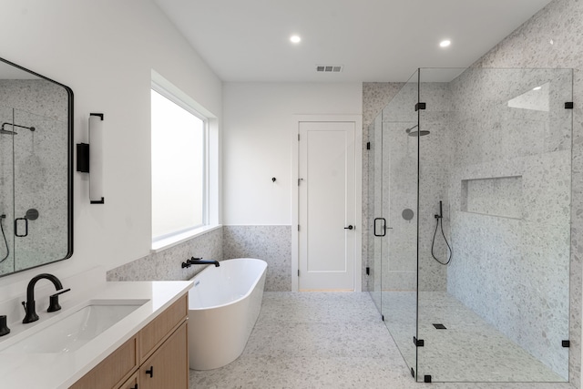 bathroom featuring vanity, tile walls, and independent shower and bath