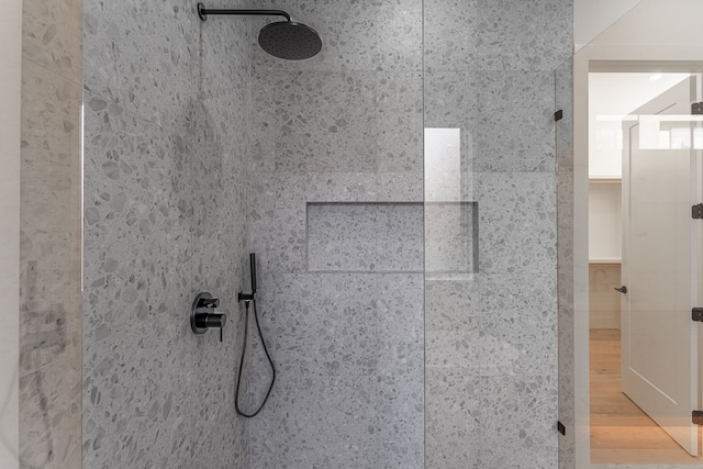 details featuring wood-type flooring and tiled shower