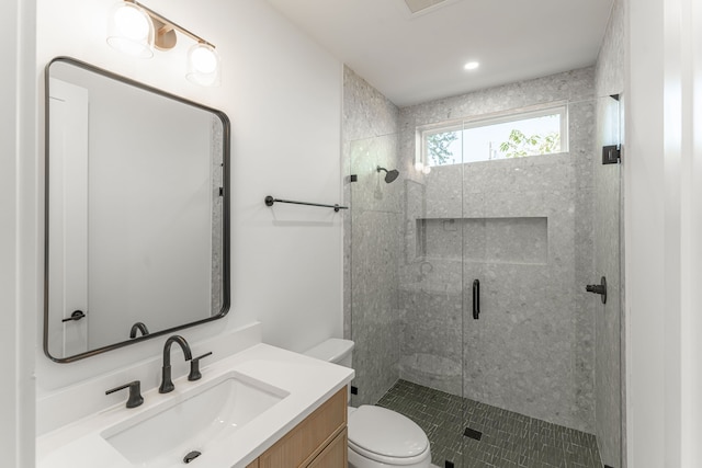 bathroom featuring vanity, toilet, and a shower with shower door