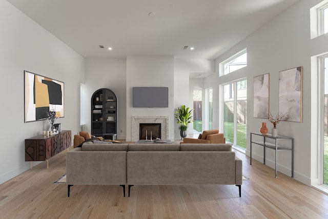 living room with light hardwood / wood-style floors and a high ceiling