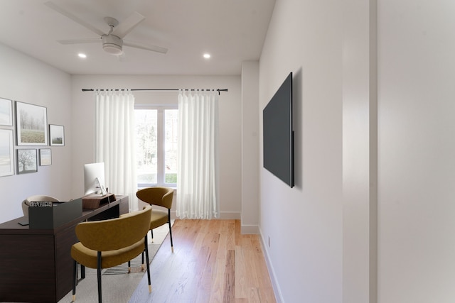 living area featuring light hardwood / wood-style floors and ceiling fan