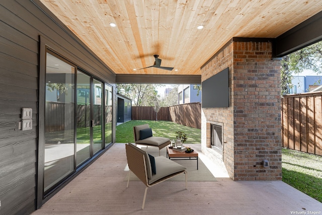 sunroom featuring ceiling fan and wood ceiling