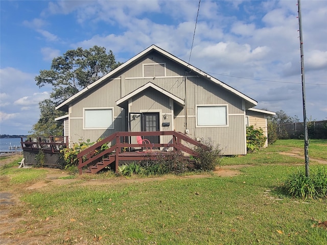 view of front of house featuring a front yard and a deck with water view