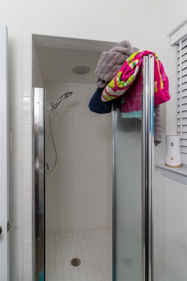 bathroom with tile patterned flooring and an enclosed shower