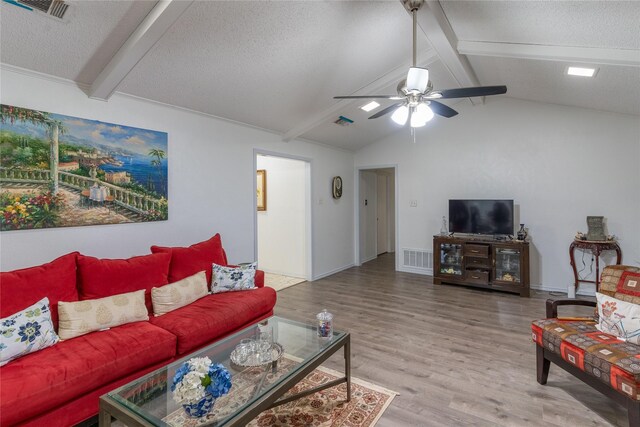 living room with vaulted ceiling with beams, ceiling fan, wood-type flooring, and a textured ceiling