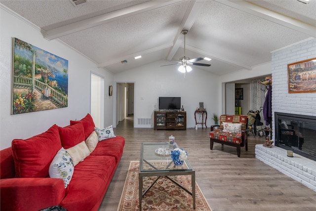 living room featuring hardwood / wood-style floors, lofted ceiling with beams, ceiling fan, and a fireplace