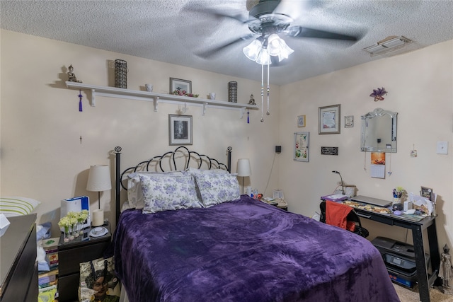 carpeted bedroom with ceiling fan and a textured ceiling