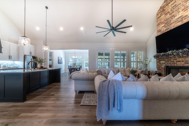 living room with a fireplace, dark hardwood / wood-style floors, high vaulted ceiling, and ceiling fan