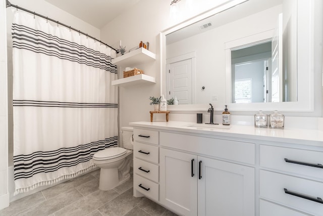 bathroom featuring tile patterned flooring, vanity, and toilet