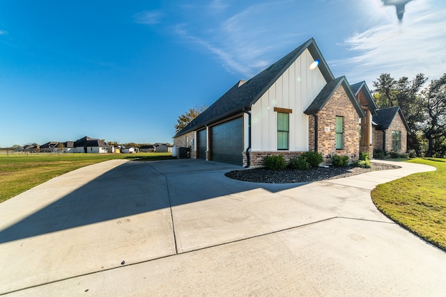 view of side of home featuring a lawn and a garage