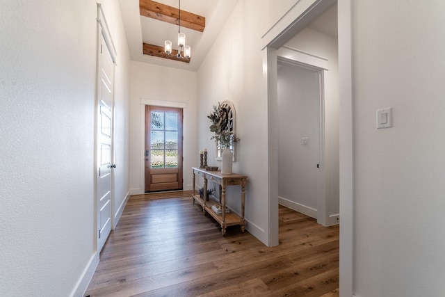 doorway to outside with beamed ceiling, wood-type flooring, and an inviting chandelier