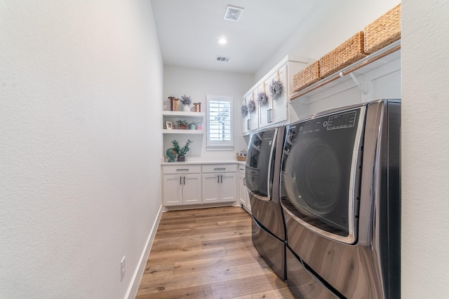 washroom with cabinets, light wood-type flooring, and independent washer and dryer