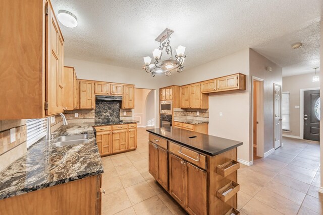 kitchen with backsplash, a kitchen island, black appliances, and sink