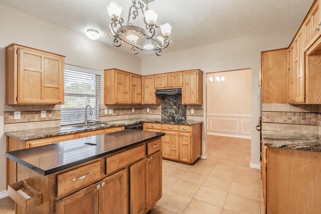 kitchen with a textured ceiling, decorative light fixtures, light tile patterned floors, and sink