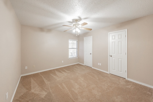 unfurnished bedroom featuring ceiling fan, light colored carpet, and a textured ceiling