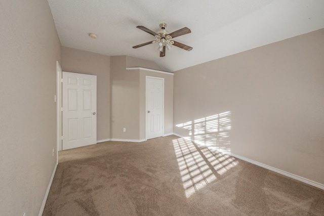 carpeted empty room with ceiling fan and lofted ceiling