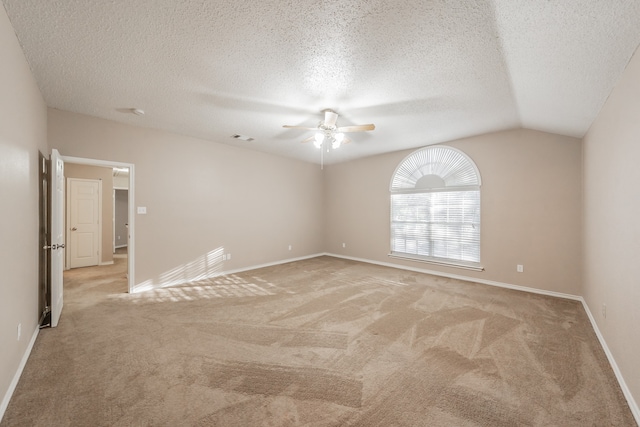 carpeted empty room featuring a textured ceiling, ceiling fan, and lofted ceiling