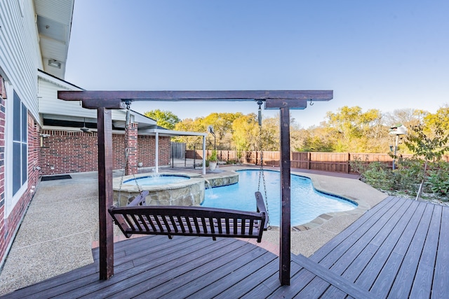 view of swimming pool featuring pool water feature, a deck, and an in ground hot tub