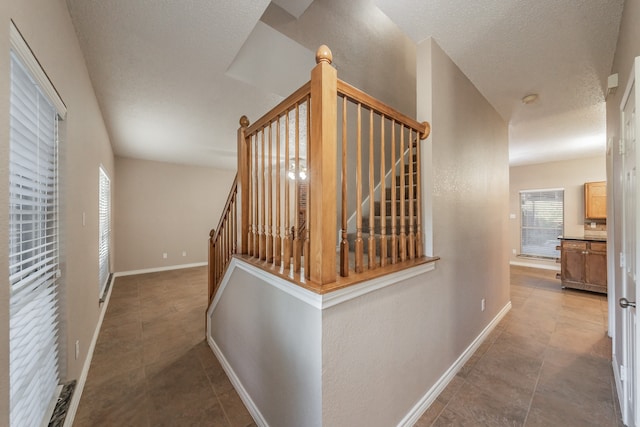 hall with plenty of natural light and light tile patterned floors