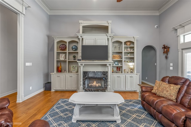 living room featuring a fireplace, ornamental molding, and hardwood / wood-style flooring