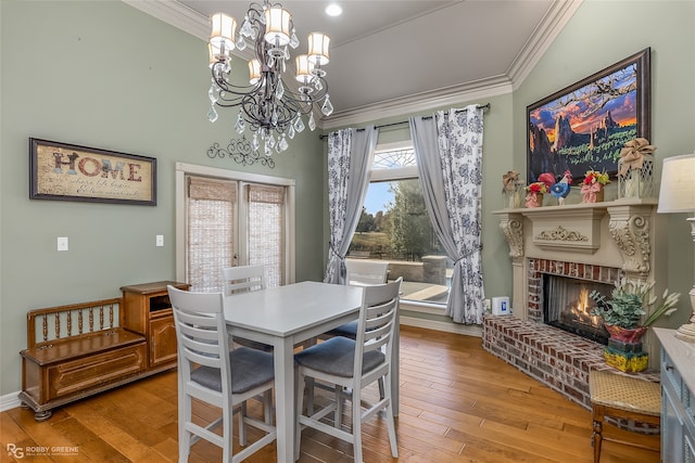 dining room featuring a fireplace, light hardwood / wood-style floors, a chandelier, and ornamental molding