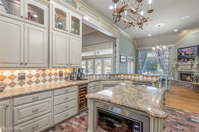 kitchen with wine cooler, tasteful backsplash, a wealth of natural light, and a brick fireplace