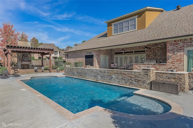 view of swimming pool featuring a patio and an outdoor stone fireplace